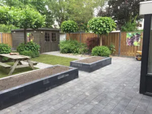 Klassieke tuin met verhoogde plantvakken, picknickbank en tuinhuis